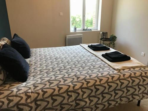 a bedroom with a bed with two pillows on it at PAUSE NATURE SORBAIS gîte 2 personnes avec grand SPA privatif, STREAMING et arrivée autonome in Sorbais