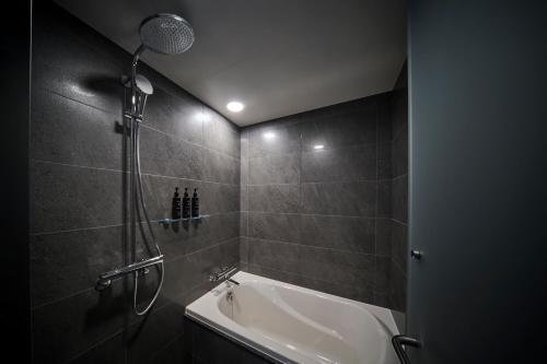 a bathroom with a shower and a bath tub at The Royal Park Hotel Iconic Nagoya in Nagoya