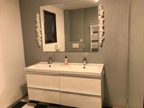 a bathroom with a white sink and a mirror at PAUSE NATURE SORBAIS gîte 2 personnes avec grand SPA privatif, STREAMING et arrivée autonome in Sorbais