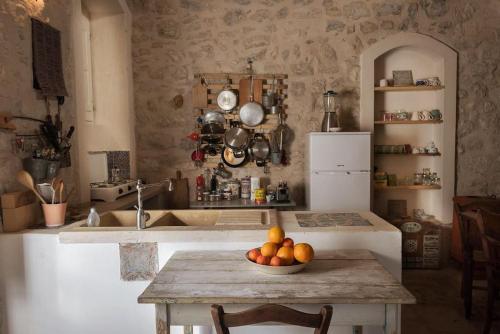 a kitchen with a table with a bowl of fruit on it at the garden among lemons in Scicli