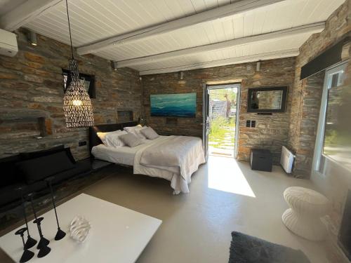 - une chambre avec un lit et un mur en pierre dans l'établissement Villa Sandra Maria, à Vourkari