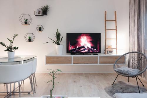 a living room with a flat screen tv on a entertainment center at Apartman Franko - SELF CHECK IN in Osijek