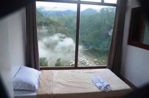 een bed in een kamer met een groot raam bij Batad Roberto's Abung Inn and Restaurant in Banaue