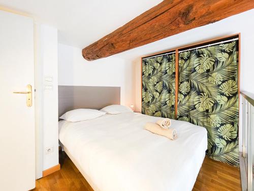 a bedroom with a white bed with a tropical wallpaper at Place Massena 4Pers Hyper Center AC in Nice