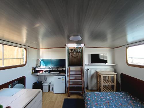 a small caravan with a kitchen and a bed at Le logement du marinier in Eckwersheim