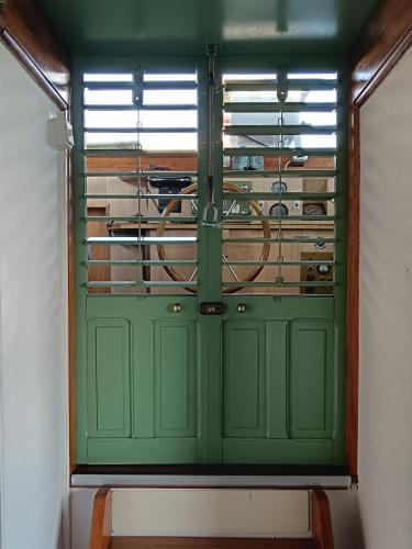 a green door with a bike in a room at Le logement du marinier in Eckwersheim