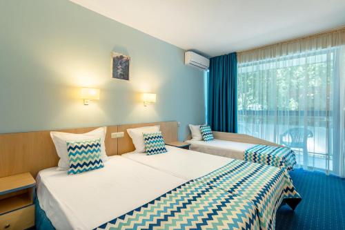 um quarto de hotel com duas camas e uma janela em BSA Holiday Park Hotel - All Inclusive em Golden Sands