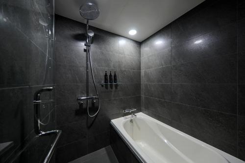 a bathroom with a shower and a bath tub at The Royal Park Hotel Iconic Nagoya in Nagoya