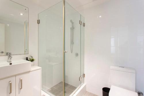 a white bathroom with a shower and a sink at Suburban Living - 2 bedroom apartment Victoria Park in Perth