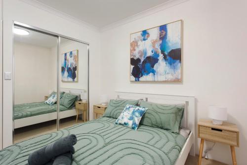a bedroom with a bed and a mirror at Suburban Living - 2 bedroom apartment Victoria Park in Perth