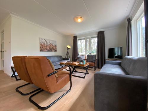 uma sala de estar com um sofá e uma mesa em Luxe familiewoning Veluwe/Garderen / Rolstoelgeschikt em Garderen