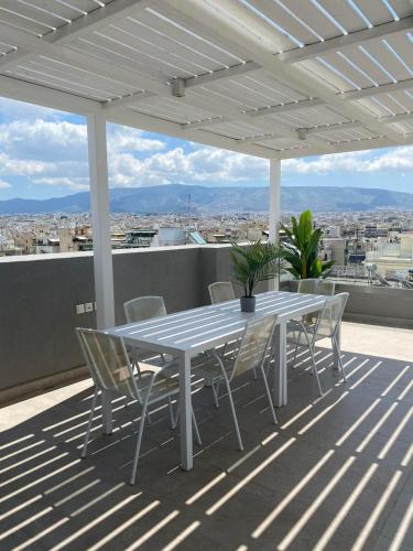 a white table and chairs on a roof at NEW 2BD APRT with SHARED ROOFTOP POOL E2 in Athens