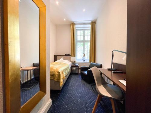 a hotel room with a bed and a desk at Hotel Wagner im Dammtorpalais in Hamburg