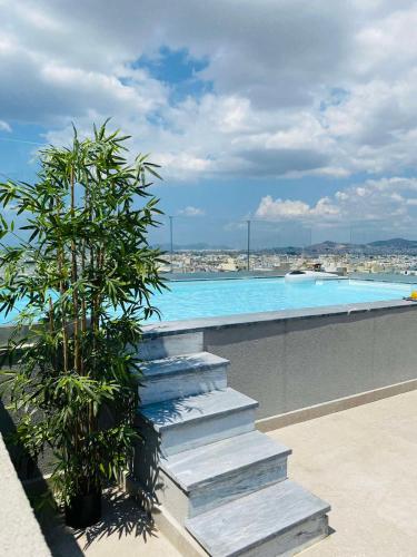 a swimming pool with stairs and a plant next to it at NEW 2BD APRT with SHARED ROOFTOP POOL E2 in Athens