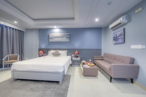 a bedroom with a bed and a couch at Ocean Pearl Hotel Phu Quoc in Phu Quoc