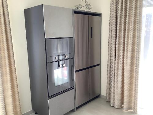 a stainless steel cabinet with an oven in a room at Colonno Panoramica Lago Di Como in Colonno