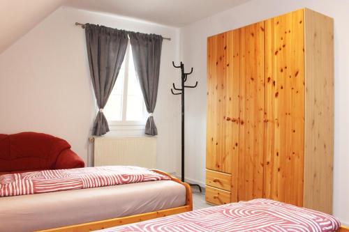 a bedroom with two beds and a wooden cabinet at Ferienwohnung Zum Gerdautal in Böddenstedt