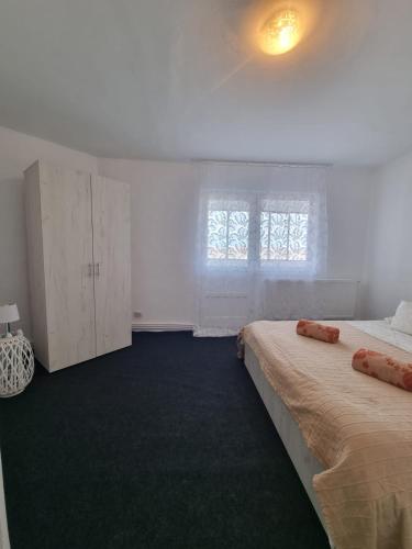 una camera bianca con due letti e una finestra di Apartament cu o camera a Hunedoara