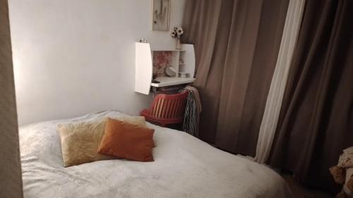 une chambre avec un lit et une chaise rouge dans l'établissement Charmante chambre spacieuse et lumineuse, à Paris