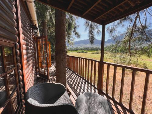 a porch of a house with chairs and a tree at Vindoux Tree House Guest Farm & Spa in Tulbagh