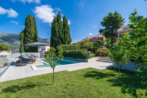 a villa with a swimming pool and a yard at Villa Laperosa in Cavtat