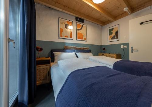 a bedroom with two beds with blue sheets at Ambrosia Hüsli in Rheinfelden