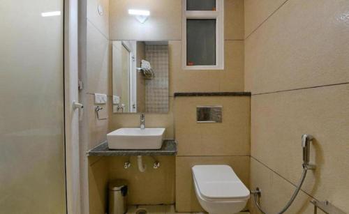 a small bathroom with a toilet and a sink at Hotel The RASA at Vasundhara in Ghaziabad