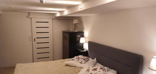 ein kleines Schlafzimmer mit einem Bett und einem schwarzen Schrank in der Unterkunft Lütt Hus in Heringsdorf