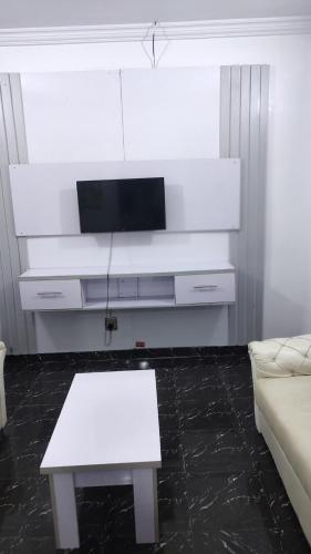 a living room with a white couch and a table at WHITE EMIRATES HOTEL AND APARTMENT in Akinde