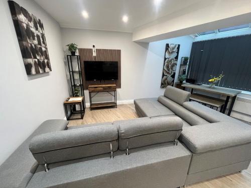 a living room with a couch and a television at Westhill Road Apartment in Bournemouth