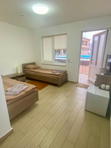 a room with two beds and a living room at Гостинний дім Александрія in Berehove