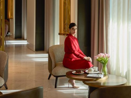 a woman sitting on a chair in a room at Fairmont Ramla Serviced Residences in Riyadh