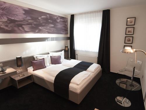 a hotel room with a large bed and a window at Good Morning Berlin City West in Berlin