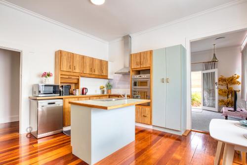 a kitchen with wooden cabinets and a counter top at Villa near CBD and Globox Arena in Hamilton