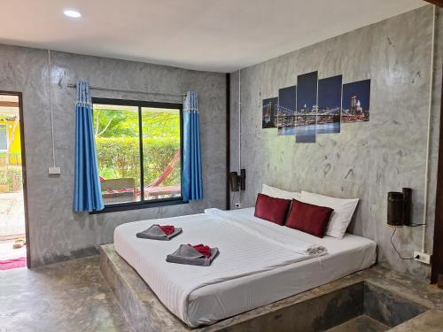 Schlafzimmer mit einem großen weißen Bett und blauen Vorhängen in der Unterkunft Lanta Happy House in Ko Lanta