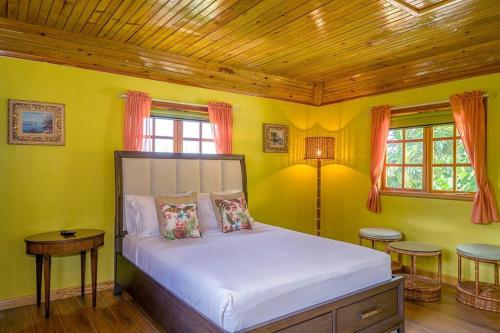 ein Schlafzimmer mit einem Bett in einem Zimmer mit gelben Wänden in der Unterkunft Private Tiny House w/ Pool in Montego Bay