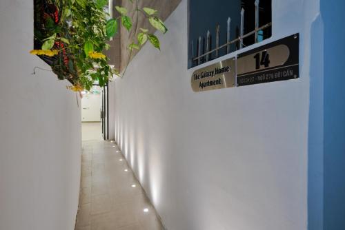 a hallway with plants and a sign on a wall at The Galaxy Home Doi Can Hotel and Apartment in Hanoi