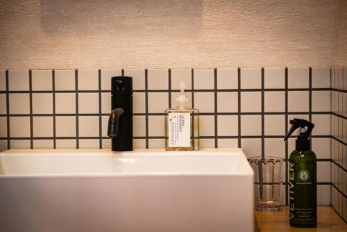 a bathroom sink with a bottle of soap on it at SHITAMACHI PLACE TOKYO in Tokyo