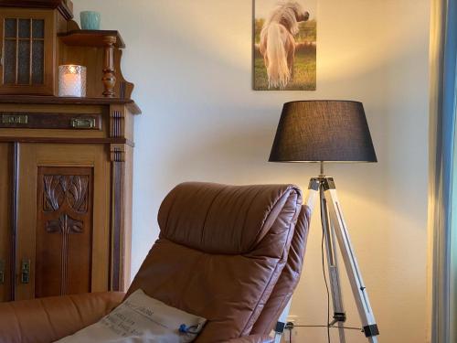 a chair and a lamp in a living room at Ferienwohnung Blick Neukoog in Nordstrand