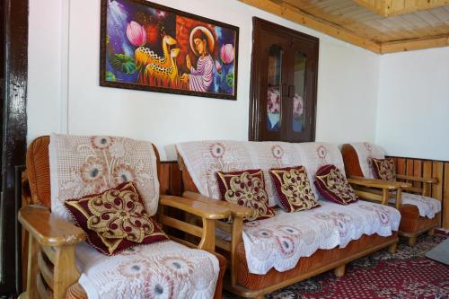 a living room with a couch and two chairs at Kin Vatika Homestay in Kalpa