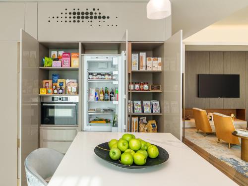 a kitchen with a table with a plate of fruit on it at Fairmont Ramla Serviced Residences in Riyadh