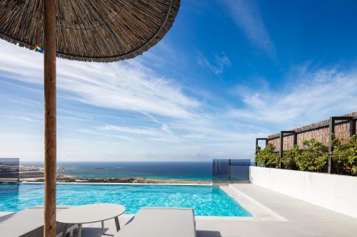 a pool with an umbrella and a view of the ocean at Falasarna village in Falasarna