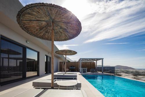 a swimming pool with an umbrella and chairs and a swimming poolvisor at Falasarna village in Falasarna