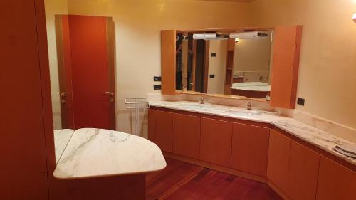 La salle de bains est pourvue de 2 lavabos et d'un grand miroir. dans l'établissement Villa Contea, à Scorzè