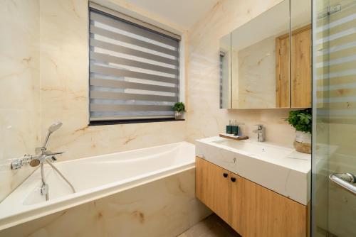 a bathroom with a tub and a sink and a tub and a mirror at The Galaxy Home Doi Can Hotel and Apartment in Hanoi