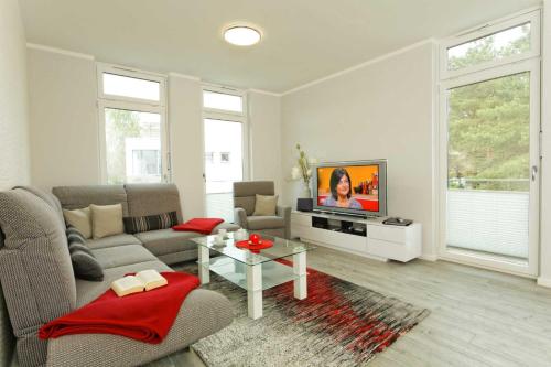 a living room with a couch and a tv at Kapitaensweg 2 Kajuete 06 in Ostseebad Karlshagen