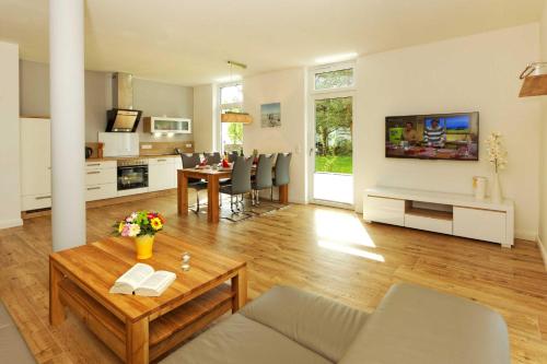 a living room with a table and a dining room at Kapitaensweg 4 Koje 01 in Ostseebad Karlshagen