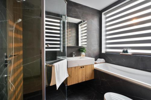 ein Badezimmer mit einem Waschbecken und einer Badewanne in der Unterkunft The Galaxy Home Doi Can Hotel and Apartment in Hanoi