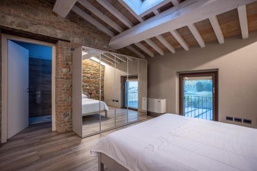 a bedroom with a white bed and a glass door at Agriturismo La Ratta in Vernasca