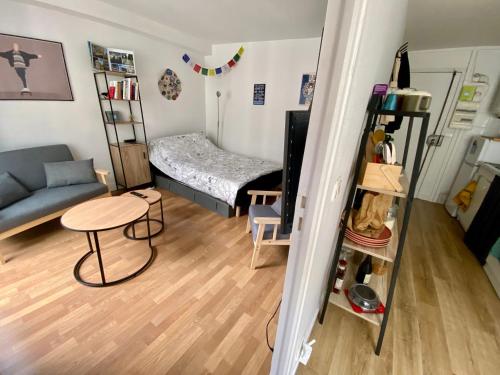 Pokój z kanapą, łóżkiem i stołem w obiekcie Appartement au coeur de Paris w Paryżu